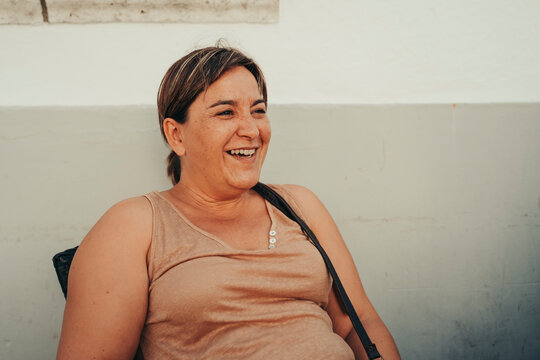 50 Year Old Woman Smiling On The Terrace Of A Bar.