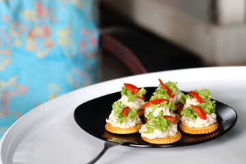 Tuna salad with crackers on black dish. Canape tuna.