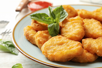 Composition with plate of chicken nuggets on white wooden background