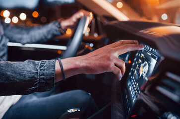 Using navigation display. Handsome unshaved man in fashionable clothes riding his automobile