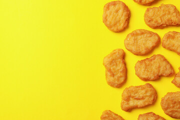 Flat lay with fried chicken nuggets on yellow background
