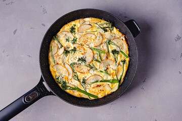 Baked egg frittata with cheese and broccolini on grey table