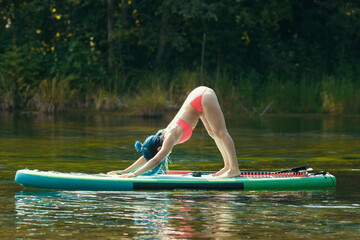 Woman with blue braids standing in aerobic pose on an inflatable boat on river