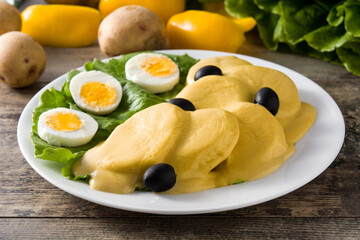 Traditional Peruvian papa a la huancaina on wooden table	