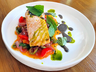 in a plate of baked Salmon with peperonata and black pepper sauce, refined Italian cuisine