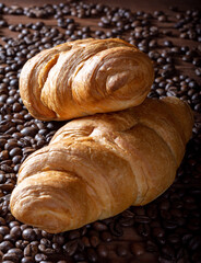 The croissants and coffee. Two croissants with coffee filling. Croissants on a wooden background.