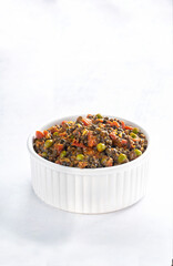 Black lentil curry on white bowl isolated on white background vertical