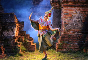 women in traditional dancer against ruin brick wall and fog.