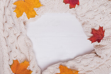 Knitted sweater, scarf or plain and yellow leaves.