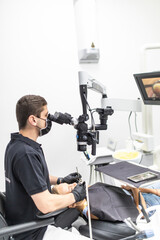 The dentist examines the patient's teeth with a dental microscope. Modern medical equipment