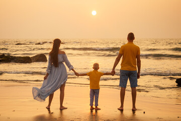 happy family looking at sunset on beach