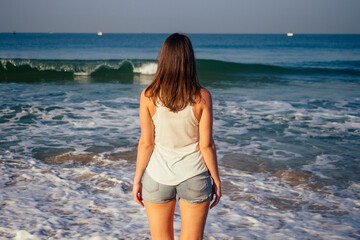 Outdoor young pretty woman posing near the sea alone