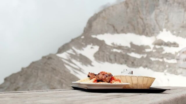 Italian Pasta With Sausage Served At The mountain hut In Muses Plateau In Mount Olympus, Greece. Throne Of Zeus View In The Background - close up