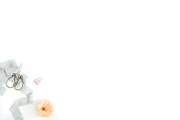 Minimal styled flat lay with assorted items and orange bloom on white background, with copy space, horizontal / vertical layout