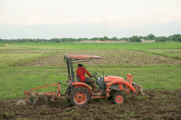 Obraz premium Tractor working plows a field on the farm for planting.