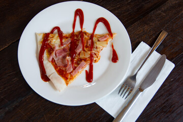 hawaiian pizza with ham, pepperoni, tomatoes on wooden table