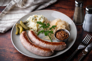 german sausage plate with mustard, potato salad and sauerkraut
