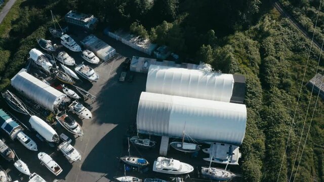 Aerial Fly over aquatic storage yard for various boats fishing deck dinghy bowrider catamaran cuddy cabin center console house boats trawlers yachts cabin cruisers while some are getting repaired 1-2