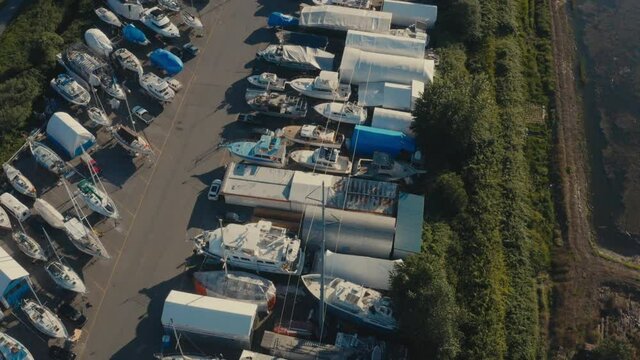 Aerial Fly over aquatic storage yard for various boats fishing deck dinghy bowrider catamaran cuddy cabin center console house boats trawlers yachts cabin cruisers while some are getting repaired 2-2