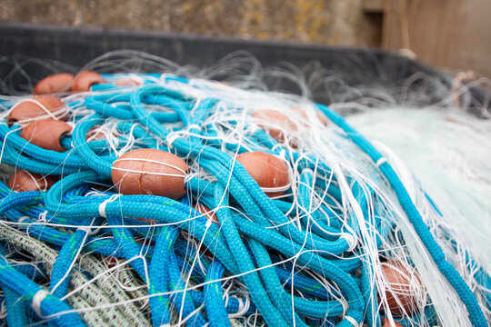 Blue fishing net with floats sitting in a box.