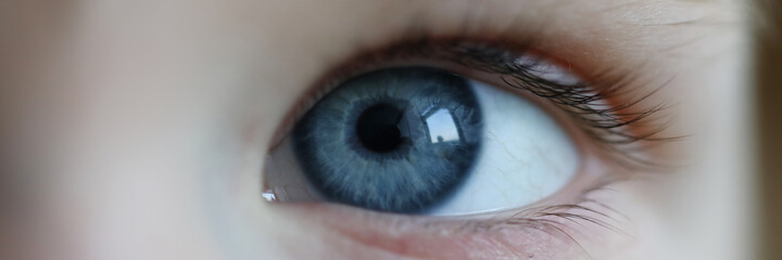 Close-up eyes cheerful child, small look at world. Innocent look, eye contact with child. Emotional and intellectual development. Charming toddler, establishing relationship. Early childhood education