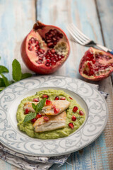 fillet fish over green peas cream with pomegranate