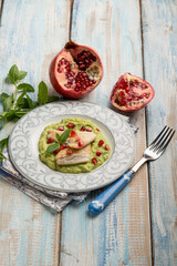 fillet fish over green peas cream with pomegranate