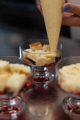 The pastry chef pours the cream into portioned forms