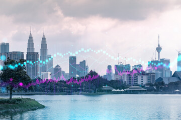 Obraz premium Świecący hologram wykresu FOREX, panoramiczny widok z lotu ptaka Kuala Lumpur o zachodzie słońca. Handel akcjami i obligacjami w KL, Malezji, Azji. Pojęcie zarządzania funduszami. Podwójna ekspozycja.