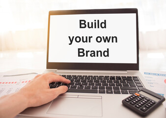 laptop with words Build your own brand on white screen, business and finance concept.