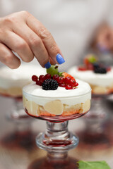 Confectioner decorates dessert with berries