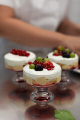 Confectioner decorates dessert with berries
