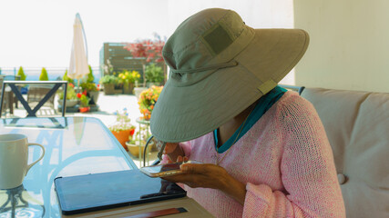 Senior with graceful hands engaging in life-long learning and staying in touch through social media while socially distancing