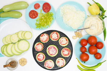 step by step recipe and ingredients for cooking homemade zucchini mini portioned pizza with mozzarella and tomatoes, pepper and garlic. top view on a light background.