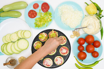 step by step recipe and ingredients for cooking homemade zucchini mini portioned pizza with mozzarella and tomatoes, pepper and garlic. top view on a light background.