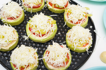 step by step recipe and ingredients for cooking homemade zucchini mini portioned pizza with mozzarella and tomatoes, pepper and garlic. top view on a light background.
