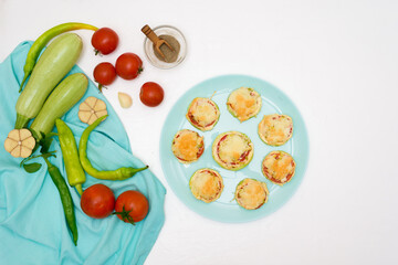 recipe and ingredients for cooking homemade zucchini mini portioned pizza with mozzarella and tomatoes, pepper and garlic. top view on a light background.