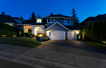 Suburban home exterior on a summer late evening with lights on yard and house - 369766786
