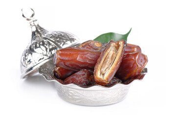 Palm dates on the silver plate, white background.