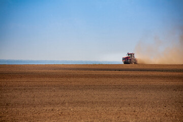 Obraz premium Tractor plowing the fields in spring
