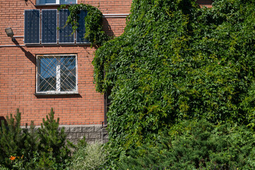 Fototapeta na wymiar Close-up of solar panels on a red brick wall. Alternative energy source. Caring for the environment.