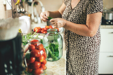 Canning vegetables tomatoes. Woman pickled preserving tomatoes herbs for canning pickling