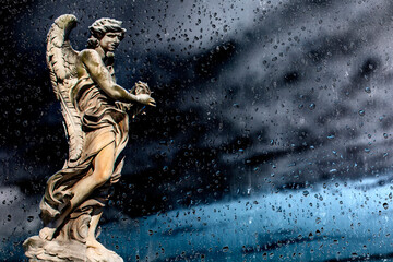 Statue of a monument to an angel on a background of dark sky.