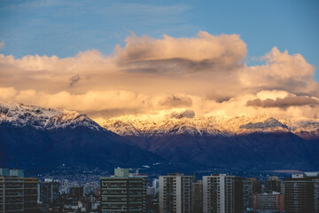 Fototapeta premium Amazing clouds and blue sky over Santiago and The Andes Mountains with a golden sunlight, Chile