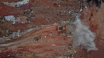bulldozer operating on landfill. Waste compaction process. Birds eye view