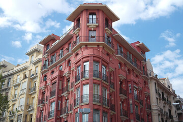 Classic building in beautiful colors under an intense blue sky and spectacular clouds. Madrid Spain
