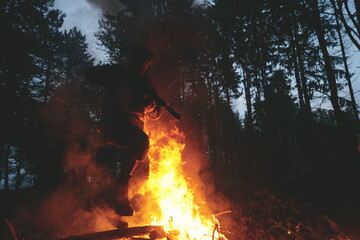 Soldier in Action at Night jumping over fire