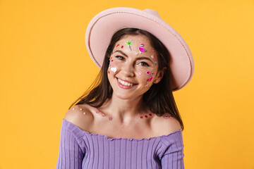 Image of young cheerful woman with stickers on face posing in pink hat