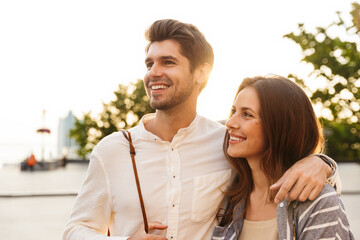 Fototapeta premium Happy beautiful couple walking in a city street
