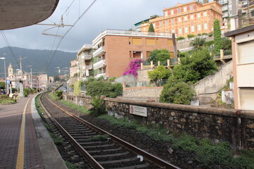 Fototapeta na wymiar The railway stretches among picturesque Italian houses